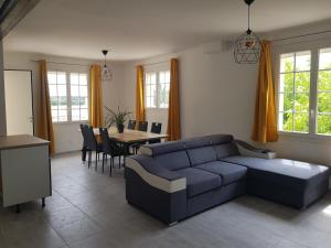 a living room with a blue couch and a table at Domaines des confines in Monteux