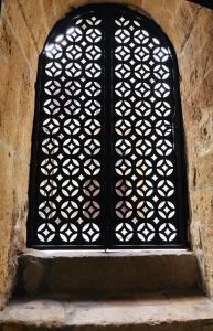 a window with a lattice design on a stone wall at Ponticelli B&B Boutique in Gravina in Puglia