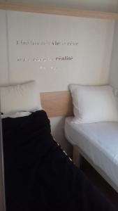 Habitación con 2 camas con una cita en la pared en Logement Insolite Utah Beach, en Sainte-Marie-du-Mont