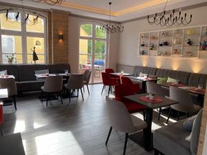 a dining room with tables and chairs and windows at Café-Hotel Gutshof in Neunkirchen