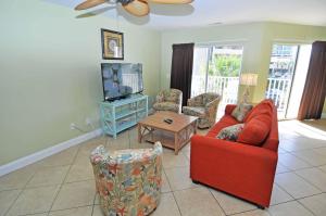 a living room with a red couch and a tv at Stunning 8 BR, New Updates, Walk to Beach Bars, Main Street in Myrtle Beach