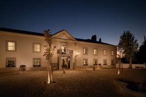 a large white building with a courtyard at night at Hotel Casa Palmela - Small Luxury Hotels of The World, Hotel & Villas in Setúbal