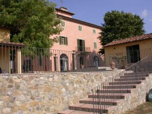 a building with a stone wall and stairs in front at Agriturismo Torraiolo in Barberino di Val dʼElsa