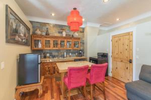 una cucina con tavolo e due sedie rosa di Lotus Mountain Suites East Suite a Ouray