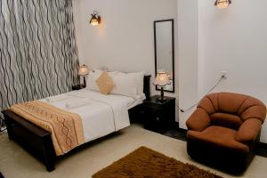 a bedroom with a bed and a chair at 4 Aces Ella in Ella