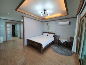 a bedroom with a bed and a ceiling at Namhae Manheim pension in Namhae