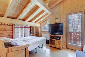 a bedroom with a bed and a flat screen tv at Le Tournavel in Praz-sur-Arly