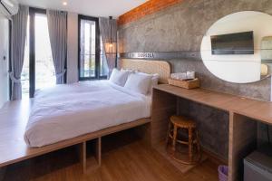 ein Schlafzimmer mit einem großen Bett und einem Spiegel in der Unterkunft The Singha Hotel - Korat in Nakhon Ratchasima