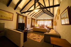 a large living room with a couch and a tv at Hostal San Nicolás in Ubaté