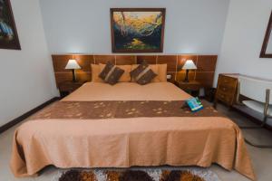 a bedroom with a large bed and two lamps at HOTEL ACHALAY in Popayan