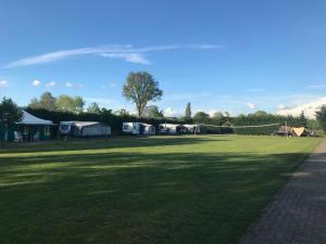 ein großes Grasfeld mit Zelten und einem Netz in der Unterkunft Recreational Farm Camping de Kreitsberg in Zeeland