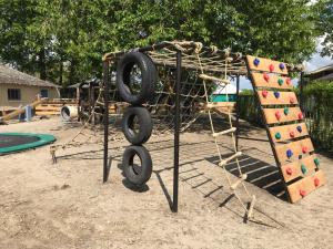 a playground with a rope and a swing set at Boerderijcamping de Kreitsberg in Zeeland