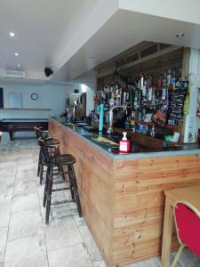 a bar in a restaurant with chairs and a piano at The Antelope Hotel in Merthyr Tydfil