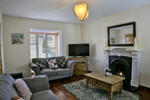 a living room with a couch and a fireplace at Village Lodge - Carlingford in Carlingford