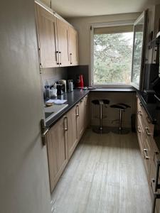 uma cozinha com armários de madeira e uma janela em Chambre d hote au calme em Brétigny-sur-Orge