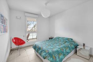 une chambre avec un lit et une chaise rouge dans l'établissement Beautiful And Spacious Apt At 19 Min From Downtown, à Toulouse