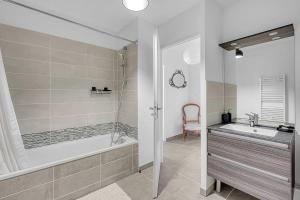 une salle de bain blanche avec une baignoire et un lavabo dans l'établissement Beautiful And Spacious Apt At 19 Min From Downtown, à Toulouse