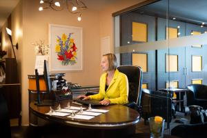 a woman sitting at a desk with a computer at Hotel & Restaurant Alte Schule in Siek