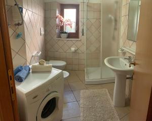 un bagno con lavatrice e lavandino di Casa Ziu Juanne a Orosei Altre 4 foto