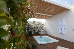 a hot tub in a room with a plant at Musae Relais & SPA in Polignano a Mare