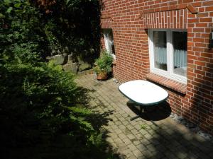 a white table sitting in front of a brick building at Helle Komfortwohnung in Möhnesee