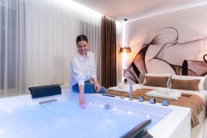 a woman sitting in a bath tub in a hotel room at Princ Apartment in Niš