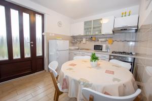a kitchen with a table and chairs and a kitchen with white appliances at Apartman Vito in Labin