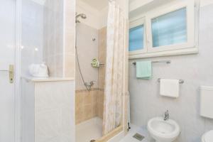 a bathroom with a shower and a toilet and a sink at Apartman Vito in Labin +7 photos