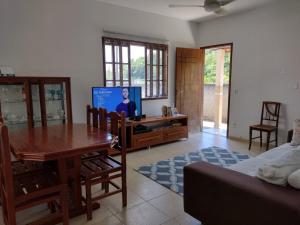 a living room with a tv and a dining room table at Espaço familiar com piscina em Penedo in Penedo