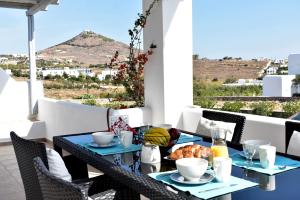 einen Tisch mit Teller mit Speisen auf dem Balkon in der Unterkunft Parodise Apartment in Kampos Paros