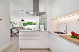 a white kitchen with white cabinets and a sink at Villa do Pinhal in Olhos de Água