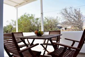 una mesa de madera con sillas y un bol de fruta. en Parodise Apartment en Kampos Paros