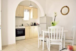 a kitchen with a table and chairs and a white refrigerator at Parodise Apartment in Kampos Paros