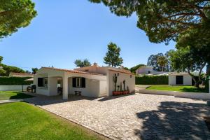 a large white house with a gravel driveway at Villa do Pinhal in Olhos de Água