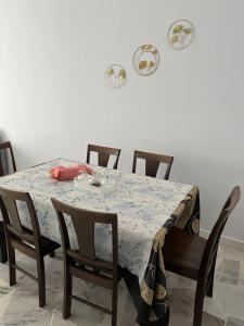 a dining room table with chairs and a white wall at AF Family Guesthouse in Port Dickson