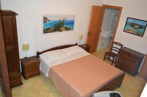 a bedroom with a bed and a chair in it at Le Anfore Appartamenti in Lampedusa