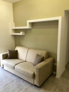 a couch sitting in a living room with shelves at La Via del Mare in Licola
