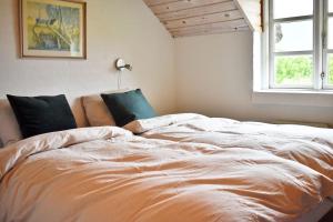 a large bed in a room with a window at Viking Surf Cottage in Klitmøller