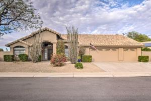 a house with a flag in front of it at Luxurious Chandler Oasis with Heated Pool and Hot Tub! in Chandler