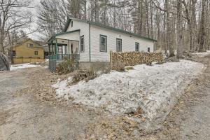 a white house with a green roof in the snow at Charming Sutton Cottage Walk to Lake and Farm! 