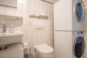 a white bathroom with a washing machine in it at Arbeitsplatz, Balkon, Tiefgarage nähe neue Messe in Leipzig +26 photos