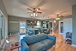 a living room with a blue couch and a kitchen at Lake Hartwell Retreat with Boat Dock and Kayaks! in Fair Play