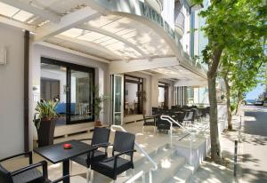 un patio avec des tables et des chaises dans un bâtiment dans l'établissement Hotel Mirabella, à Cattolica