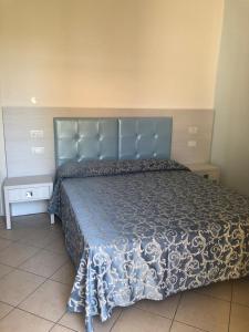 un letto con testiera blu in una camera da letto di Hotel Mirabella a Cattolica