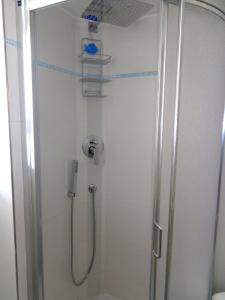 um chuveiro numa casa de banho com uma porta de vidro em Hotel Mirabella em Cattolica