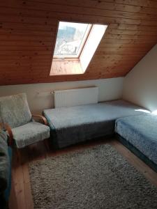 1 dormitorio con 1 cama, 1 silla y 1 ventana en apartmán Sázava, en Sázava