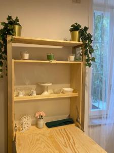 a wooden shelf with dishes and plants on it at Little House in Parma