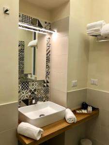 a bathroom with a sink and a mirror and towels at La Via del Mare in Licola