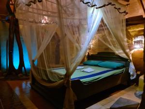 a bedroom with a canopy bed with mosquito nets at Humbhaha jungle nature eco resort in Kataragama