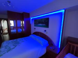 a bedroom with a bed with a blue light on it at Piso turistico Mundaka con opción a garaje in Mundaka